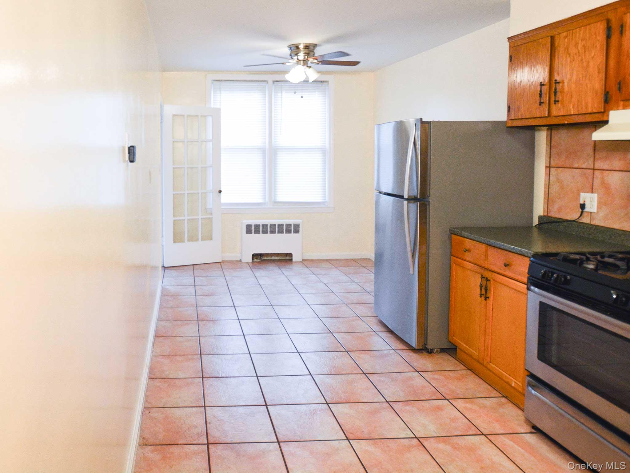 253-27 85th Road, Unit 2 Queens, NY 11426 - Photo 2 of 8 a kitchen with stainless steel appliances granite countertop a refrigerator stove and sink