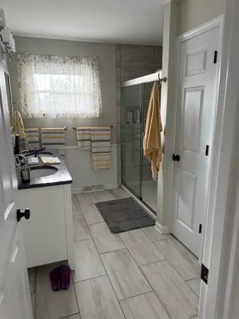 a view of a hallway with a livingroom and a bathroom