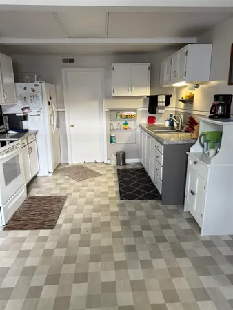 a kitchen with cabinets a sink and white appliances