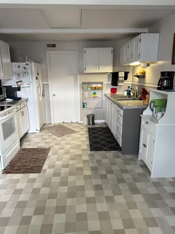 a kitchen with cabinets a sink and white appliances