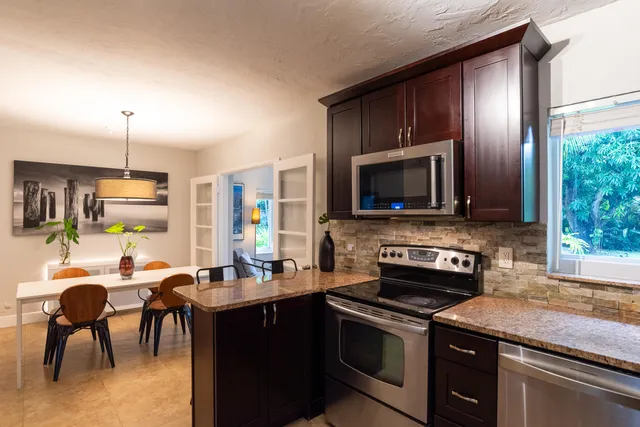 a kitchen with granite countertop a sink stove and refrigerator