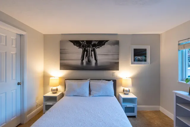 a bedroom with a bed and a painting on the wall