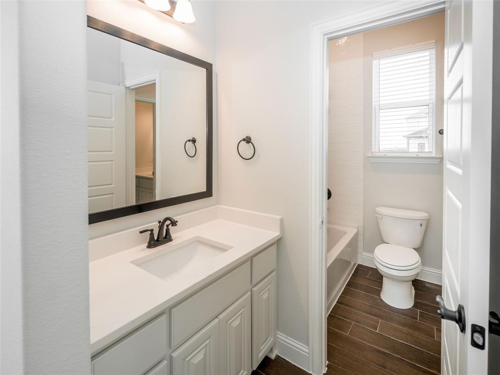 2108 Charters Circle Nevada, TX 75173 - Photo 28 of 37 a bathroom with a sink toilet a mirror and vanity