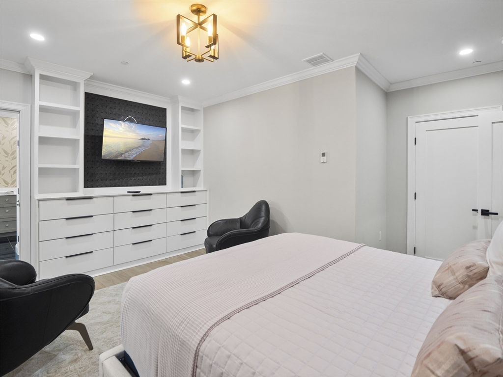 140 Middlesex Street, Unit 3 Lowell, MA 01852 - Photo 14 of 30 a bedroom with a bed and a flat screen tv