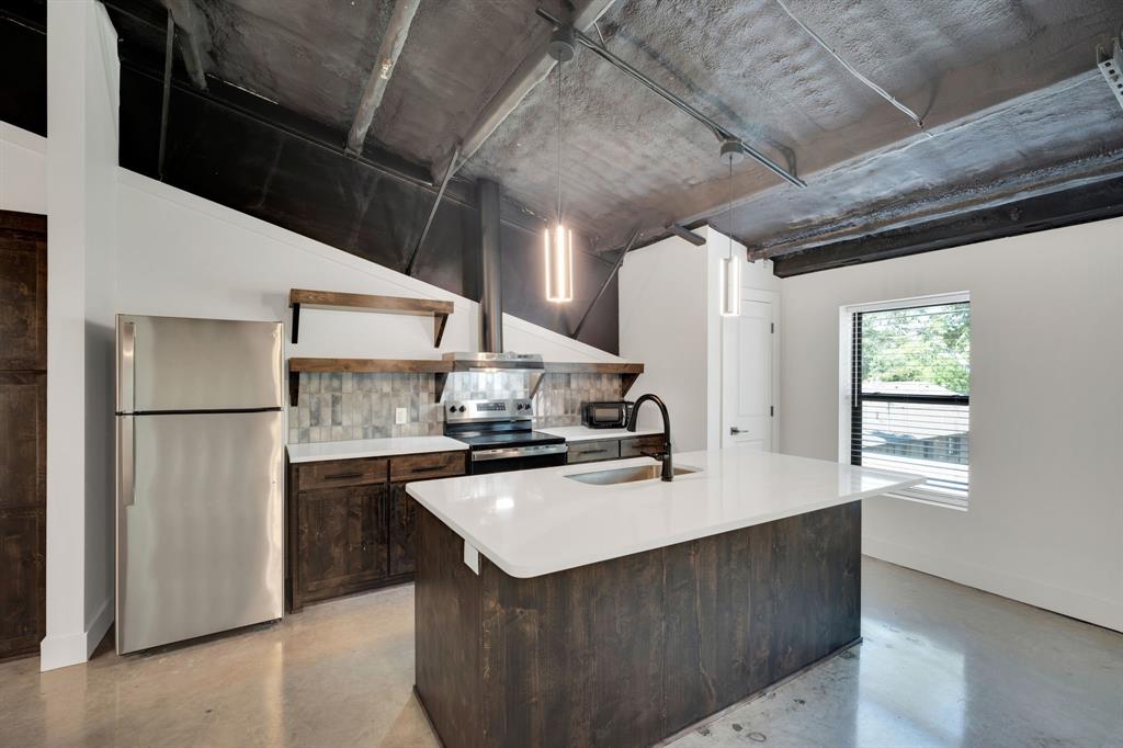 a kitchen with a sink a refrigerator and window