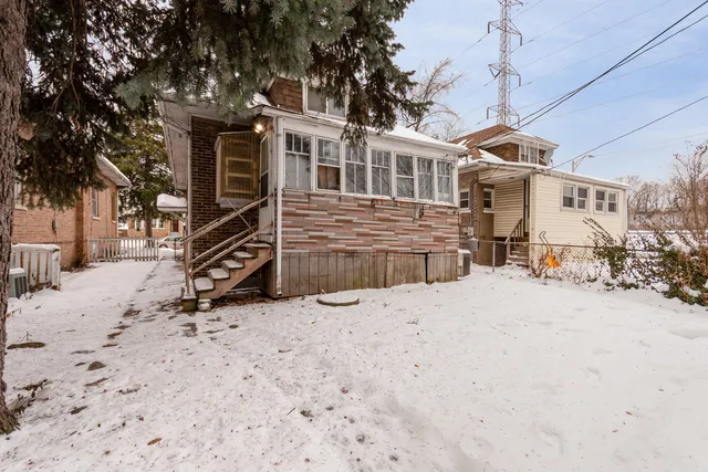 a front view of a house with a yard covered in snow