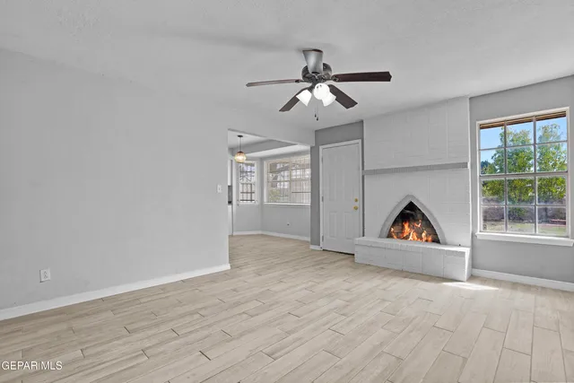 a view of a livingroom with a ceiling fan window and wooden floor
