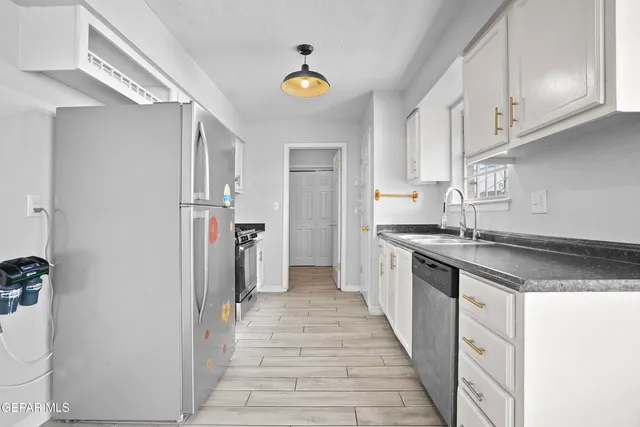 a kitchen with stainless steel appliances granite countertop a sink and dishwasher a stove with wooden floor