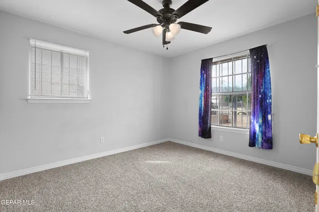 an empty room and chandelier fan