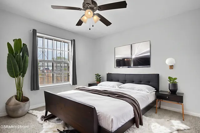 a bedroom with a bed a chandelier and a potted plant