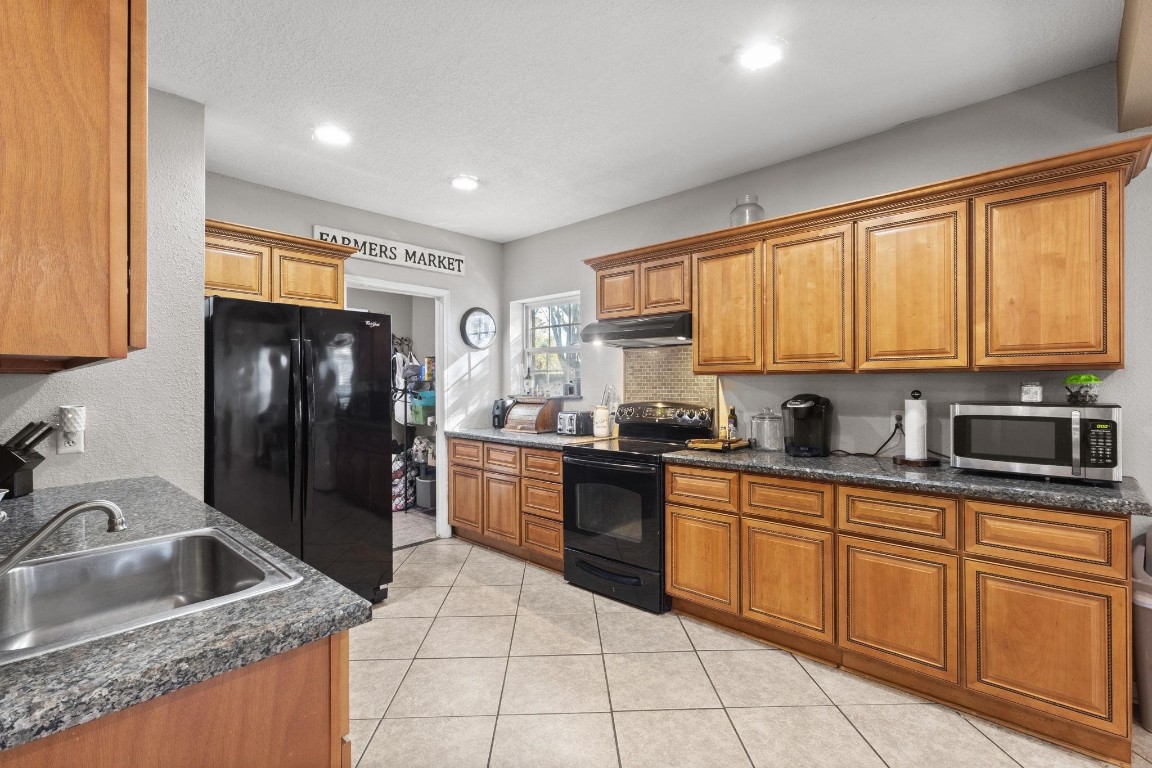 770 Katherene Avenue Bridge City, TX 77611 - Photo 11 of 29 a kitchen with granite countertop a refrigerator sink and cabinets