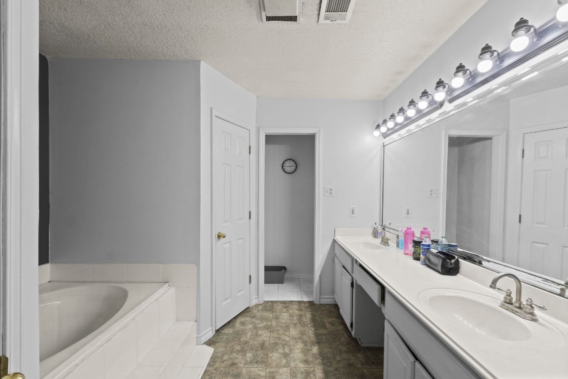 770 Katherene Avenue Bridge City, TX 77611 - Photo 21 of 29 a bathroom with a tub sink double vanity and mirror