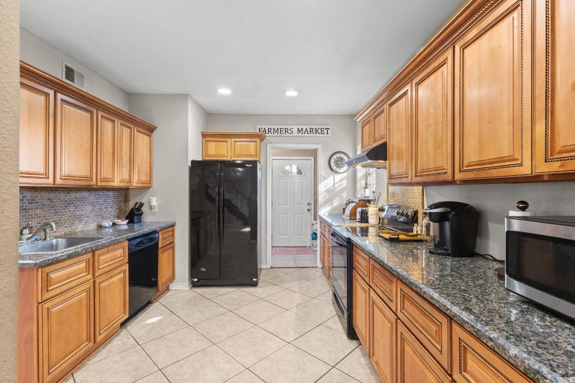 770 Katherene Avenue Bridge City, TX 77611 - Photo 10 of 29 a kitchen with granite countertop a refrigerator sink and cabinets