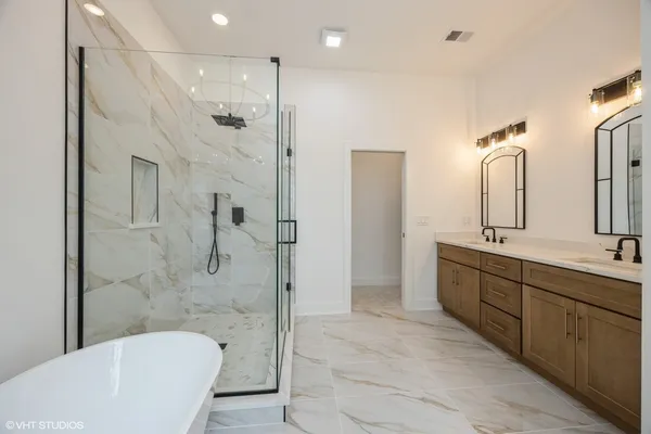 a bathroom with a bathtub shower sink mirror and toilet
