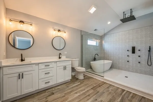 a spacious bathroom with a double vanity sink mirror and bathtub