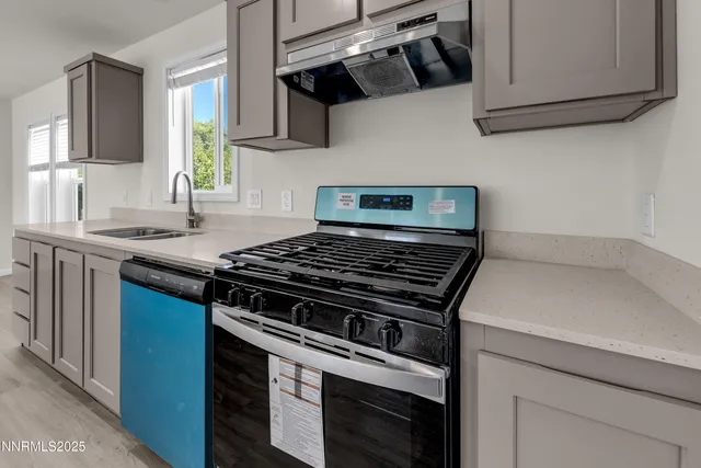 a kitchen with stainless steel appliances granite countertop a sink a stove and a microwave