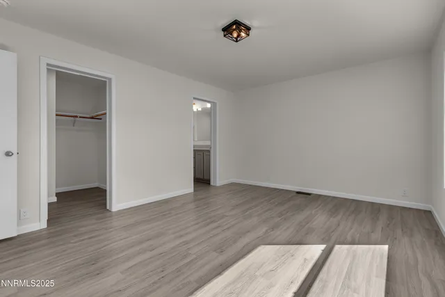 an empty room with wooden floor and closet