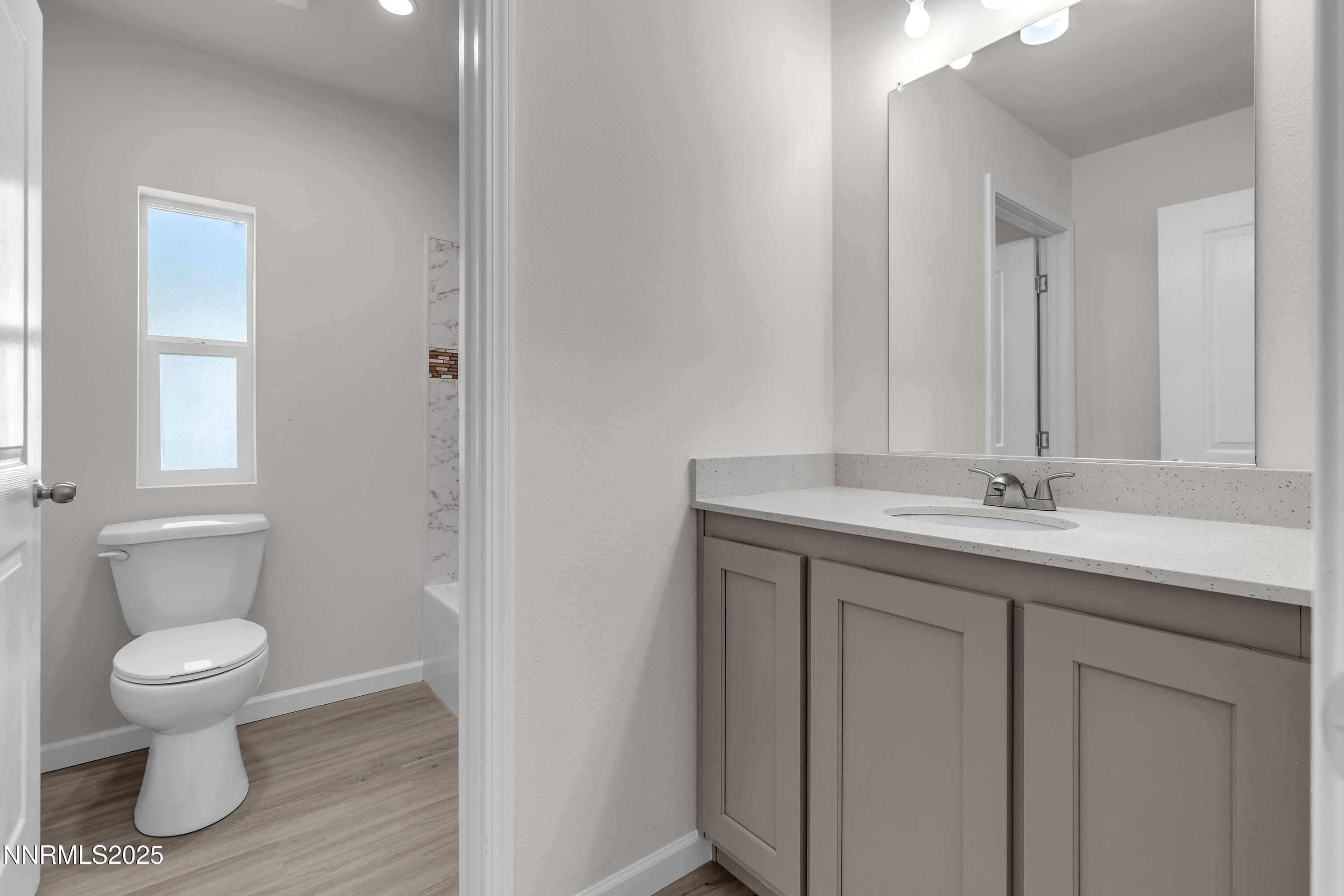 3810 Bobolink Circle Reno, NV 89508 - Photo 27 of 36 a bathroom with a granite countertop sink a toilet and a mirror