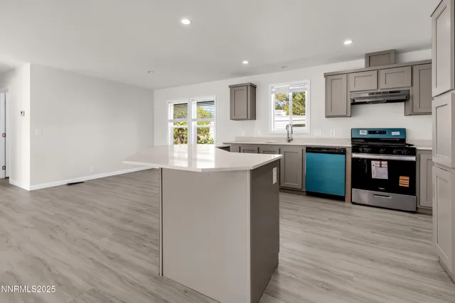a kitchen with stainless steel appliances granite countertop a sink stove and wooden floor