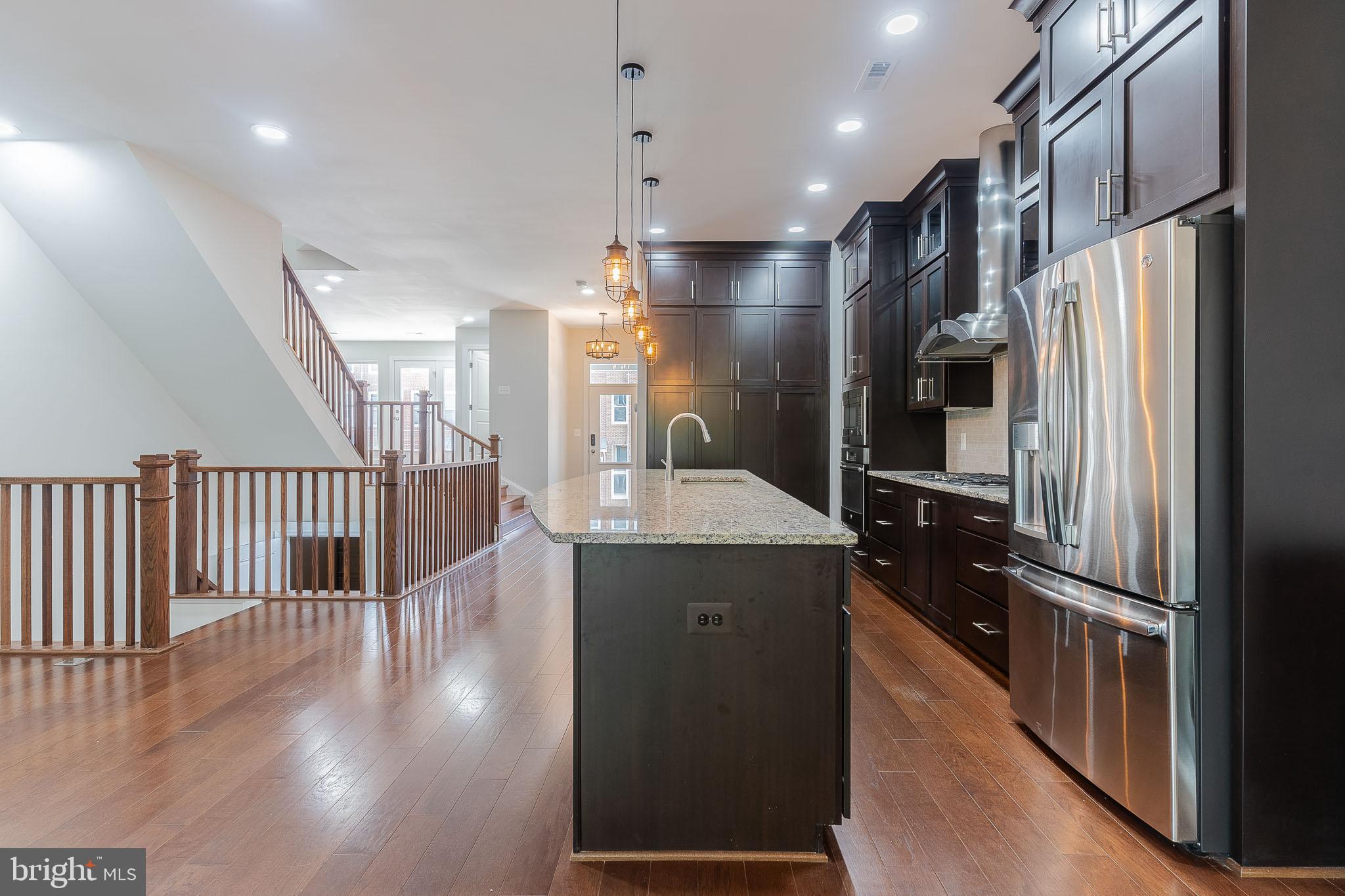 23480 Epperson Square Brambleton, VA 20148 - Photo 11 of 50 a kitchen with stainless steel appliances a refrigerator and a wooden floor