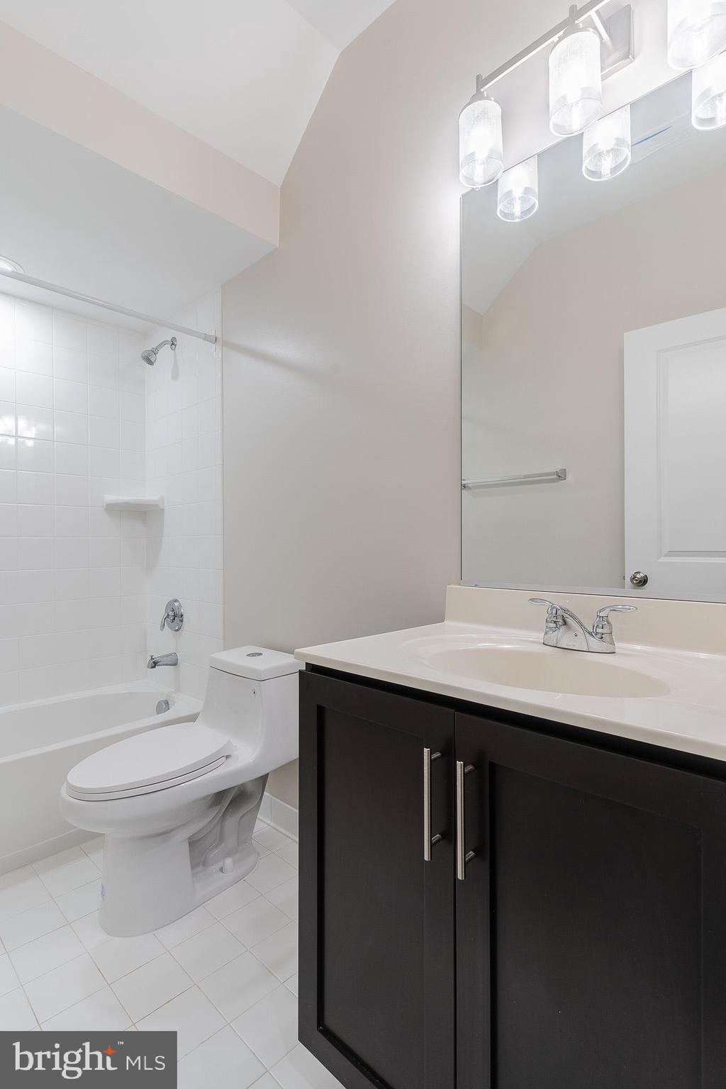 23480 Epperson Square Brambleton, VA 20148 - Photo 19 of 50 a bathroom with a sink a toilet a mirror and shower