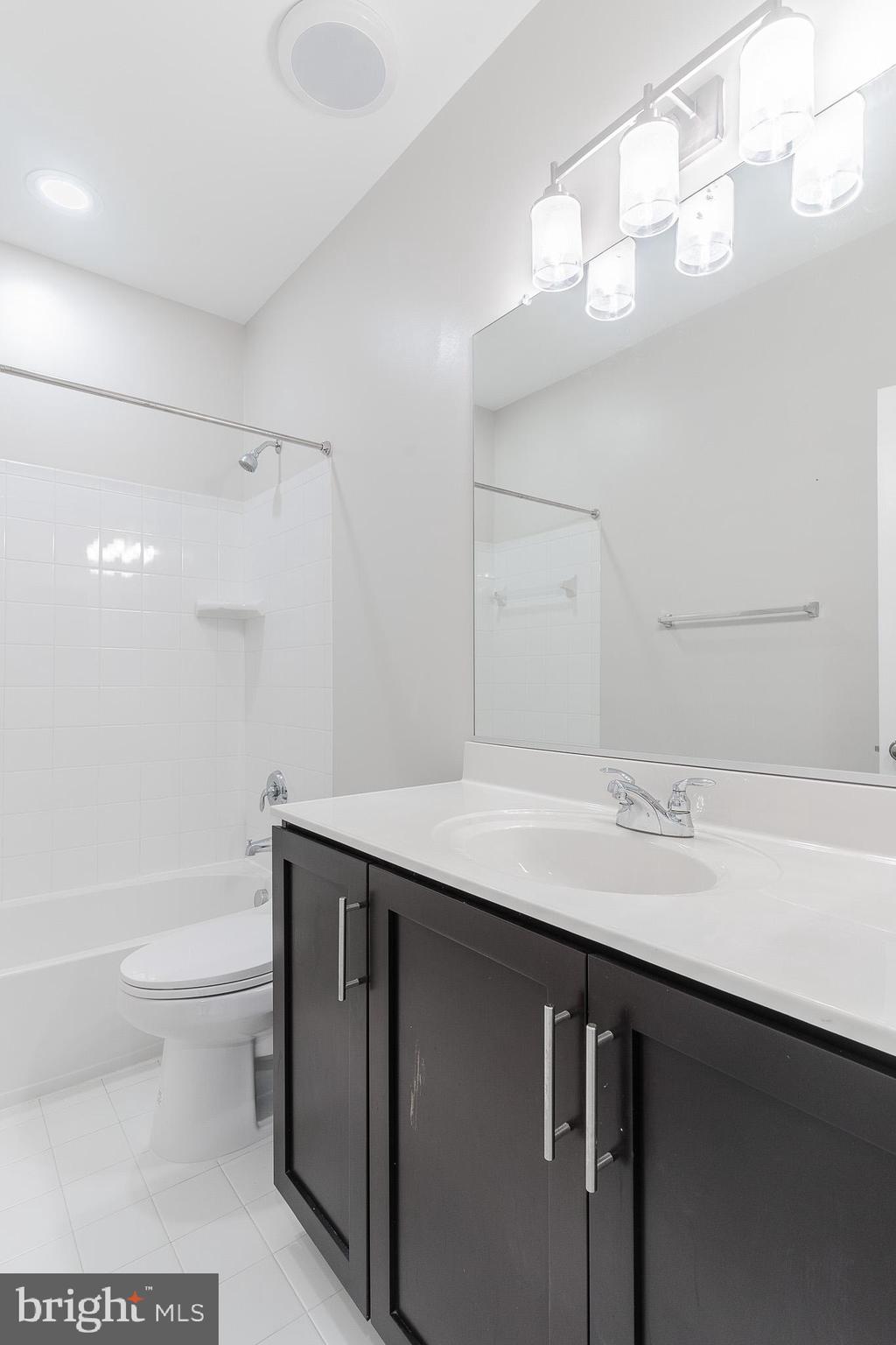 23480 Epperson Square Brambleton, VA 20148 - Photo 38 of 50 a bathroom with a sink a toilet a large mirror and shower