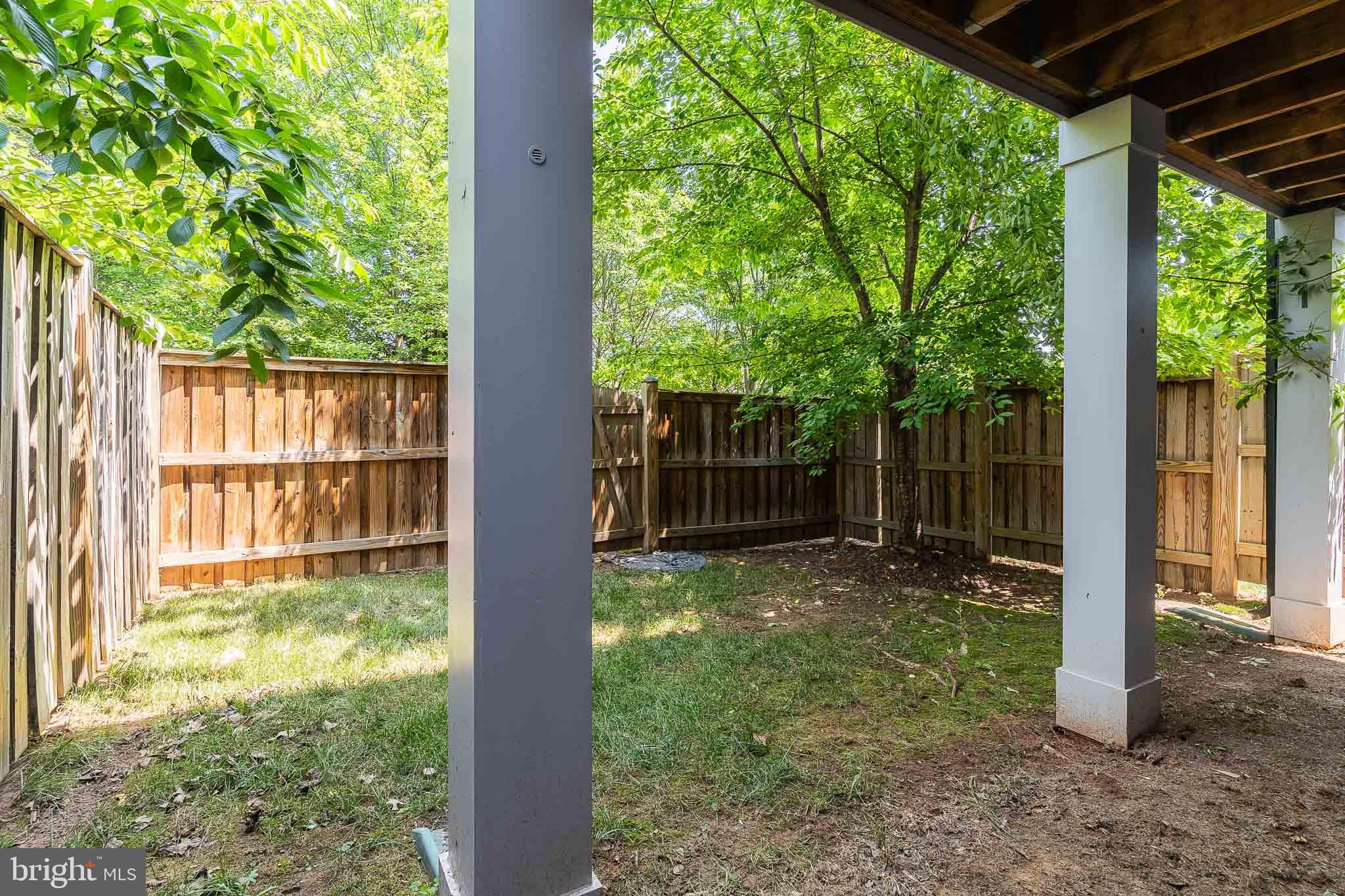 23480 Epperson Square Brambleton, VA 20148 - Photo 48 of 50 a view of a yard with a large tree and wooden fence