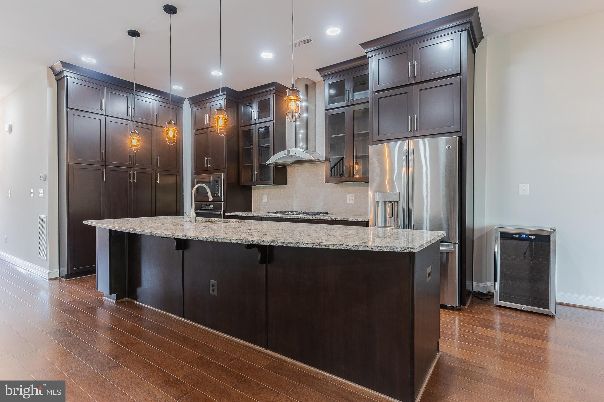 23480 Epperson Square Brambleton, VA 20148 - Photo 8 of 50 a kitchen with kitchen island a counter top space a sink and refrigerator