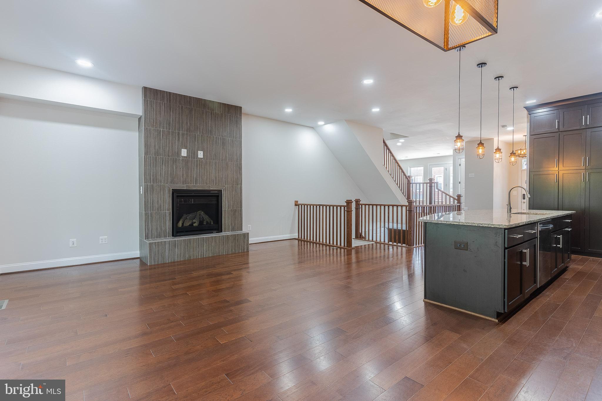 23480 Epperson Square Brambleton, VA 20148 - Photo 10 of 50 a kitchen with stainless steel appliances a refrigerator and a wooden floor