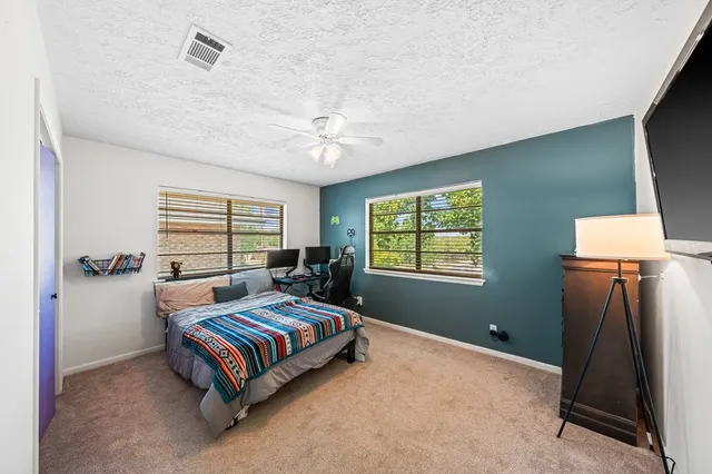 a spacious bedroom with a bed and a window