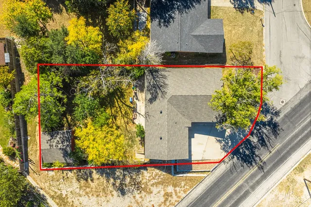 an aerial view of residential houses with outdoor space and trees