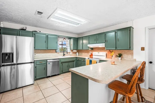 a kitchen with stainless steel appliances a refrigerator sink and wooden cabinets