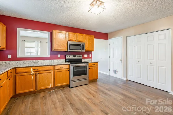 a kitchen with stainless steel appliances granite countertop a stove a sink and a microwave