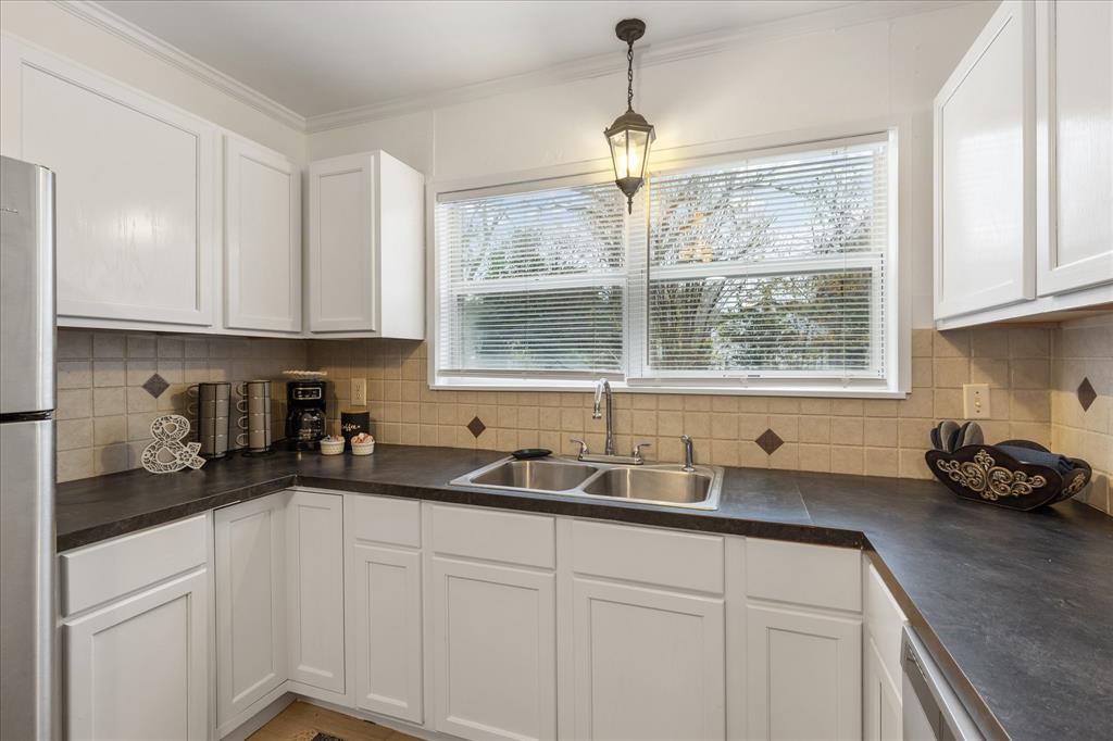 3554 Winston Road Fort Worth, TX 76109 - Photo 16 of 25 a kitchen with stainless steel appliances a sink a window and cabinets