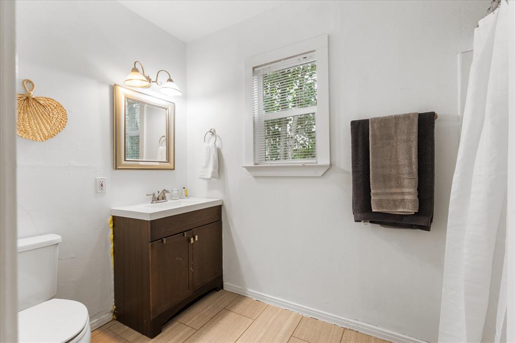 3554 Winston Road Fort Worth, TX 76109 - Photo 20 of 25 a bathroom with a toilet a sink and mirror
