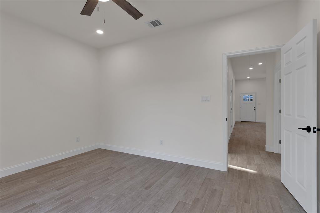 815 Southwest 28th Street Mineral Wells, TX 76067 - Photo 24 of 40 an empty room with wooden floor and windows