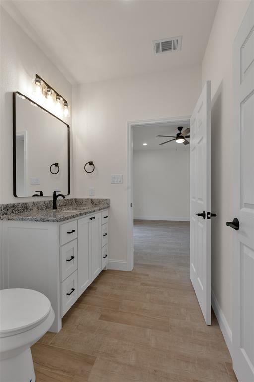 815 Southwest 28th Street Mineral Wells, TX 76067 - Photo 34 of 40 a bathroom with a granite countertop sink mirror and toilet