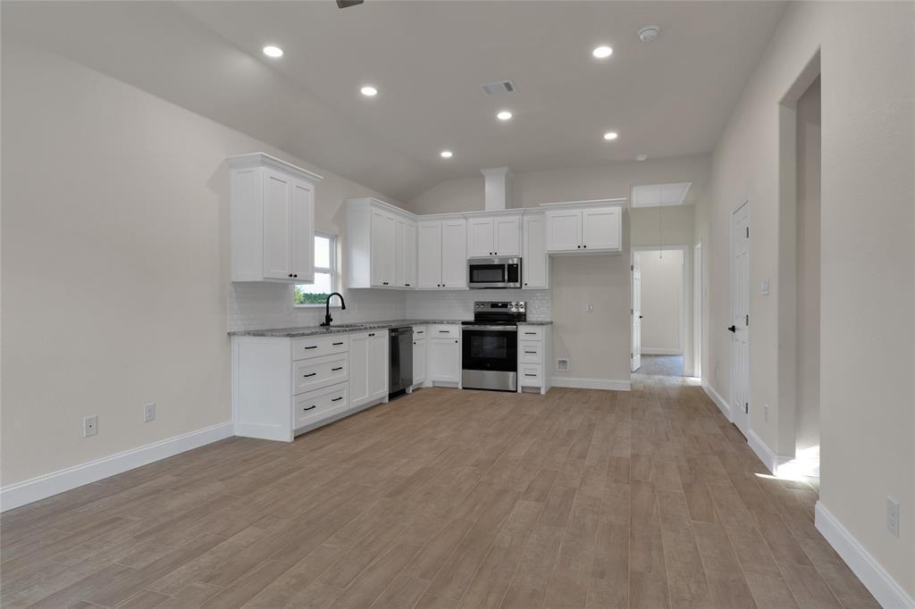 815 Southwest 28th Street Mineral Wells, TX 76067 - Photo 7 of 40 a large kitchen with cabinets and wooden floor