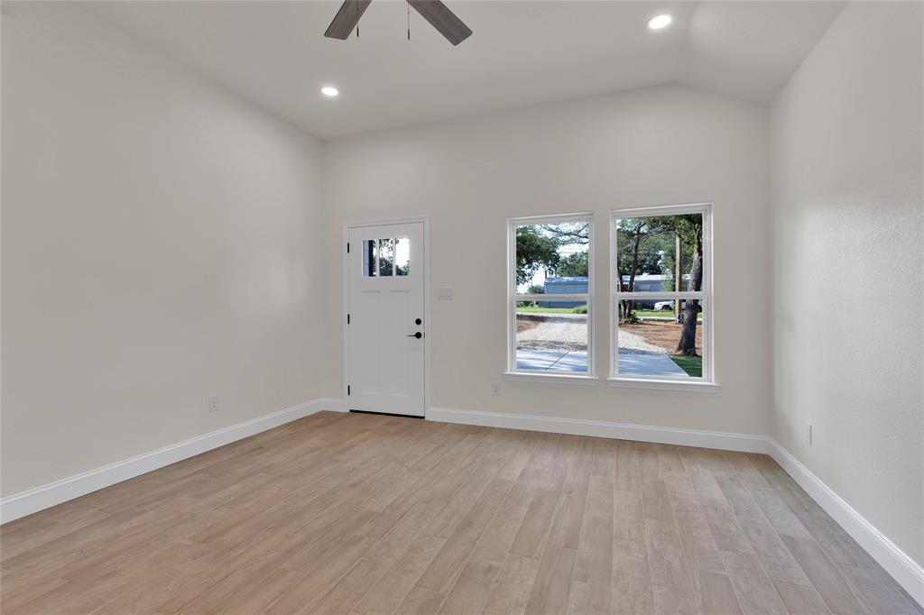 815 Southwest 28th Street Mineral Wells, TX 76067 - Photo 10 of 40 an empty room with wooden floor and windows