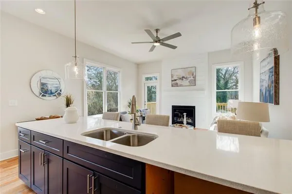 a kitchen with a sink a chandelier and a fireplace