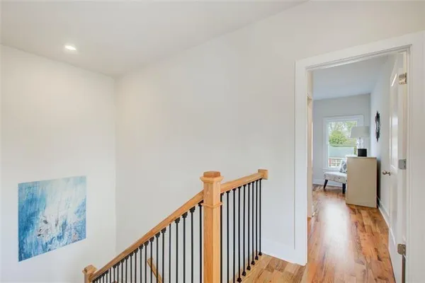 a view of a hallway with wooden floor and furniture