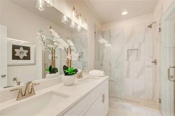 a bathroom with a double vanity sink mirror and shower