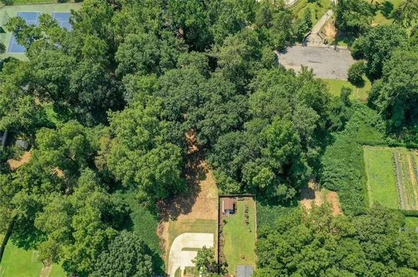 an aerial view of residential house with outdoor space and trees all around