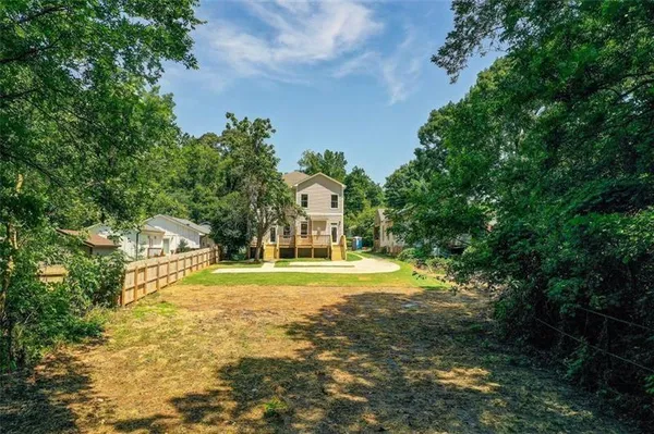 a view of a big yard with plants and large trees