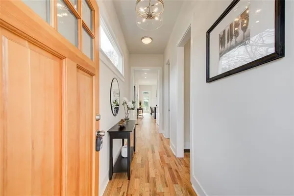 a view of a hallway with wooden floor and staircase