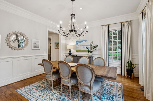a kitchen with kitchen island granite countertop a table chairs sink and cabinets