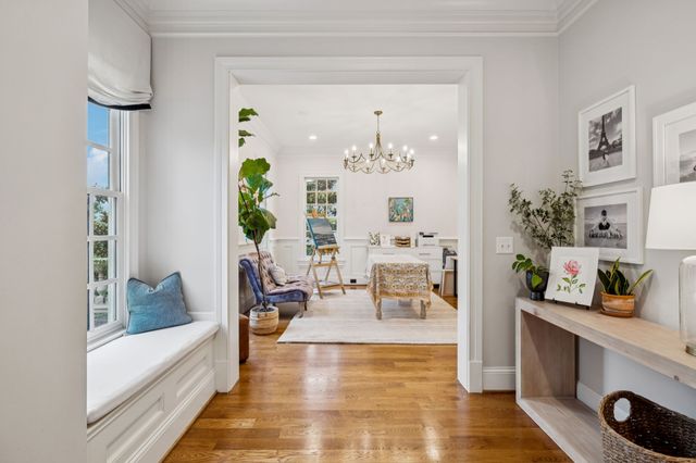 a kitchen with a white center island a stove a refrigerator cabinets and wooden floor