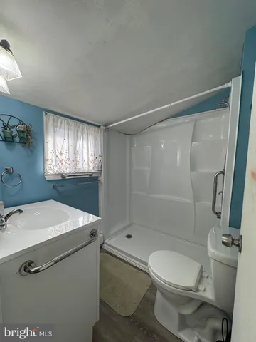 a room with a black white checkered floor with a gaming machine and wooden floor