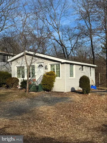 a view of a house with a large tree and many windows