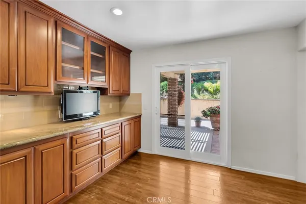 a kitchen with granite countertop a sink a stove cabinets and wooden floor